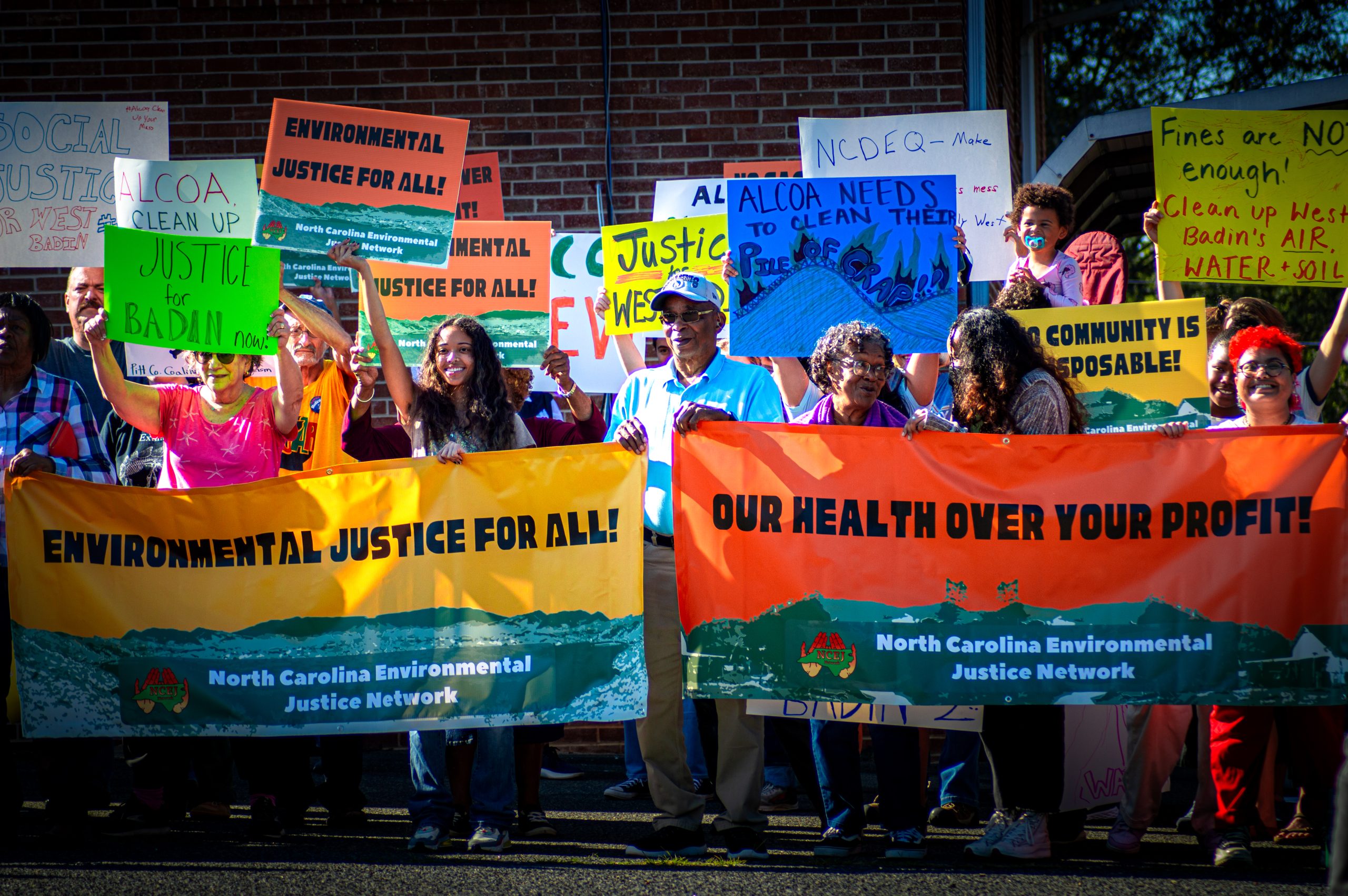 A group of people marching with signs advocating for health and justice.